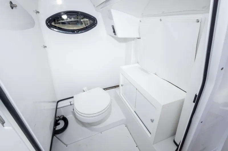 Slide: The Image of 2019 Sportsman Heritage 251 Center Console boat interior with compact marine toilet and storage. - 31