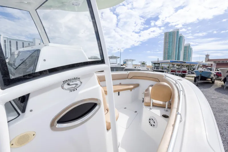 Slide: The Image of 2019 Sportsman Heritage 251 Center Console boat with seating, docked near modern buildings. - 32