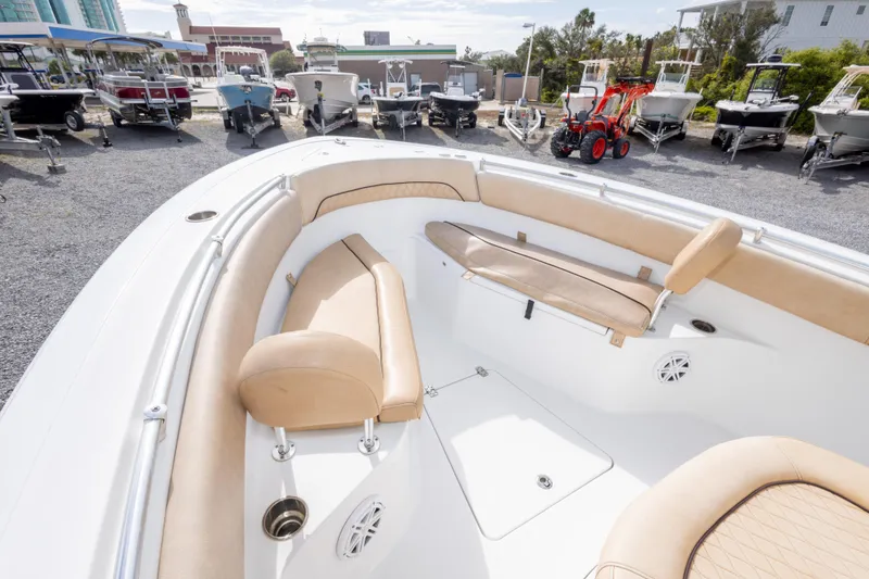 Slide: The Image of 2019 Sportsman Heritage 251 Center Console boat interior with tan seating, parked among other boats. - 34