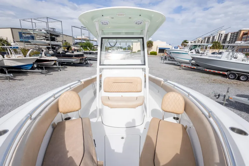 Slide: The Image of 2019 Sportsman Heritage 251 Center Console boat with beige seating, displayed outdoors. - 36