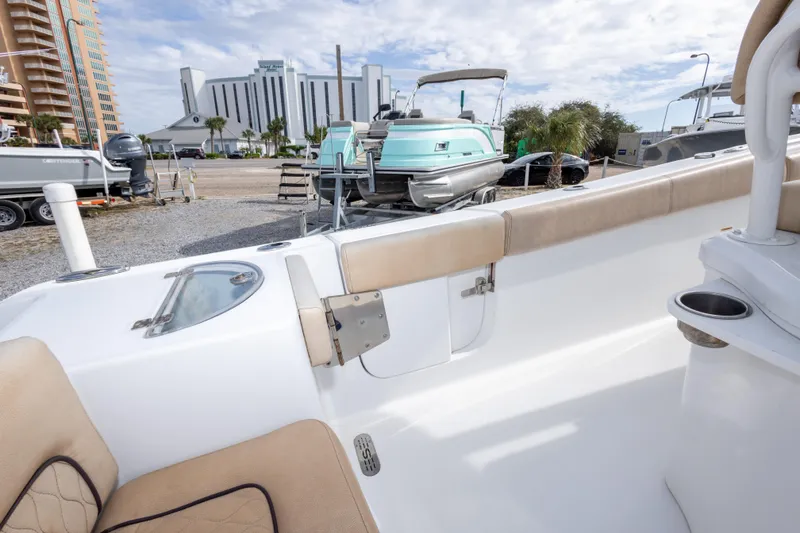 Slide: The Image of 2019 Sportsman Heritage 251 Center Console boat interior with beige seating, docked near other boats. - 42