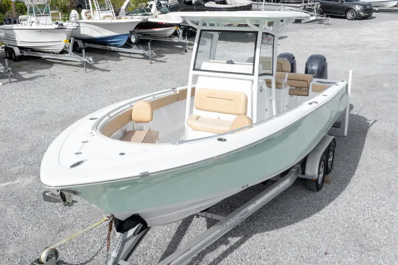 Slide: The Image of 2019 Sportsman Heritage 251 Center Console boat on trailer, parked in a gravel lot. - 8