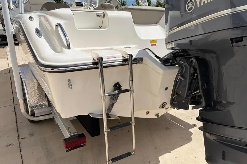 Slide: The Image of 2024 Key West 239 DFS boat with Yamaha outboard motor, parked outside a building. - 14
