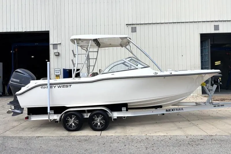 Slide: The Image of 2024 Key West 239 DFS boat on trailer, parked outdoors under cloudy sky. - 3