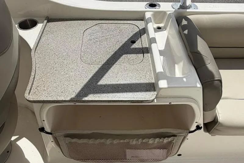 Slide: The Image of 2024 Key West 239 DFS boat interior with beige seating and motor view. - 31