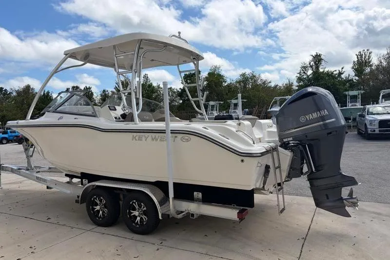 Slide: The Image of 2024 Key West 239 DFS boat with spacious seating, docked near a warehouse. - 7