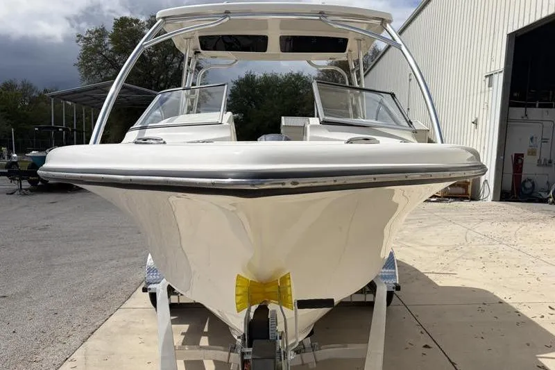 Slide: The Image of 2024 Key West 239 DFS boat on trailer, parked outside a warehouse under cloudy sky. - 8