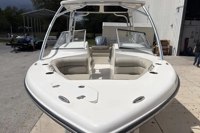 Slide: The Image of 2024 Key West 239 DFS boat on trailer, parked near a building under cloudy sky. - 9