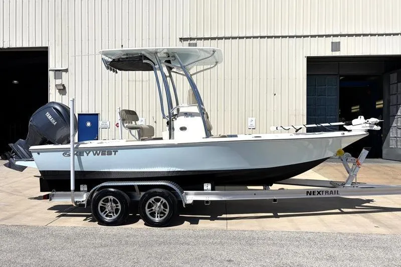 The Image of 2024 Key West 210 Bay Reef boat on trailer, parked outside a warehouse. - 0
