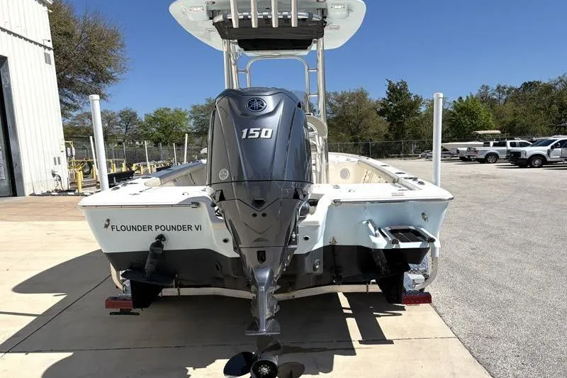 Slide: The Image of 2024 Key West 210 Bay Reef boat with Yamaha 150 engine, parked outdoors. - 12