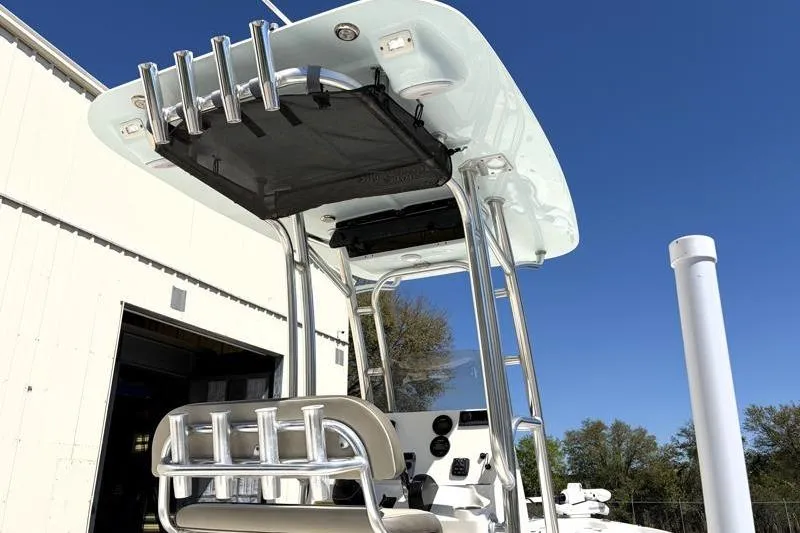 Slide: The Image of 2024 Key West 210 Bay Reef boat with T-top and rod holders against blue sky. - 16