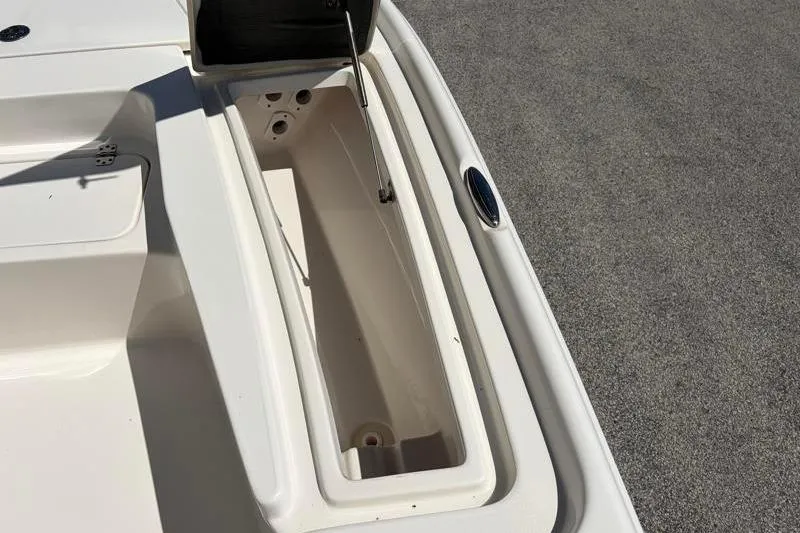 Slide: The Image of 2024 Key West 210 Bay Reef boat storage compartment, open lid, white interior. - 23