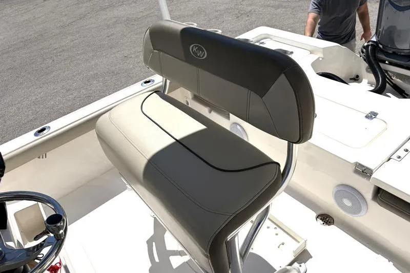 Slide: The Image of 2024 Key West 210 Bay Reef boat interior with cushioned seating and steering wheel. - 27