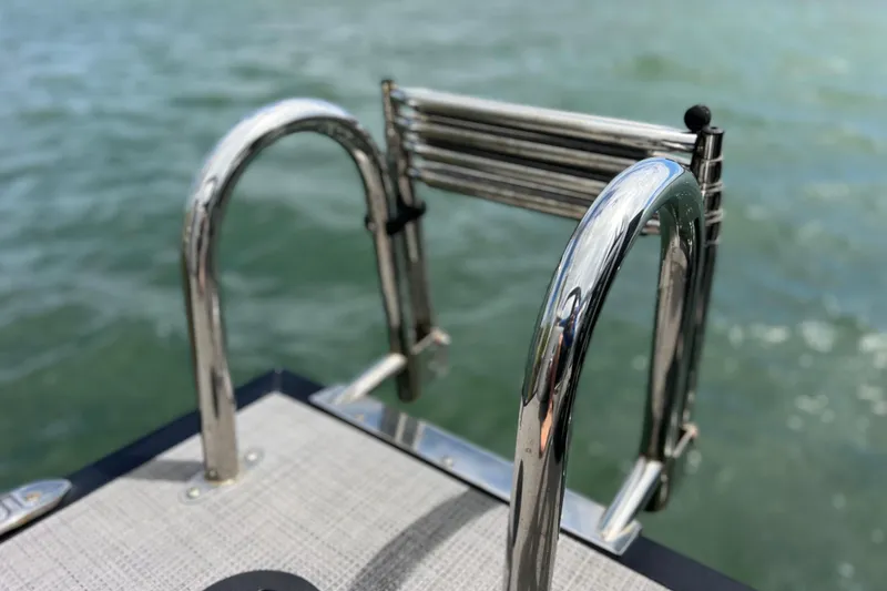Slide: The Image of Chrome ladder on 2023 Bentley Pontoons 250 Elite Admiral, overlooking water. - 12