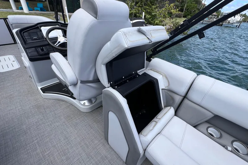 Slide: The Image of 2023 Bentley Pontoons 250 Elite Admiral interior with open storage compartment and steering console. - 17