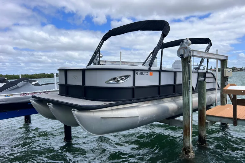 Slide: The Image of 2023 Bentley Pontoons 250 Elite Admiral docked on a lift over water. - 2