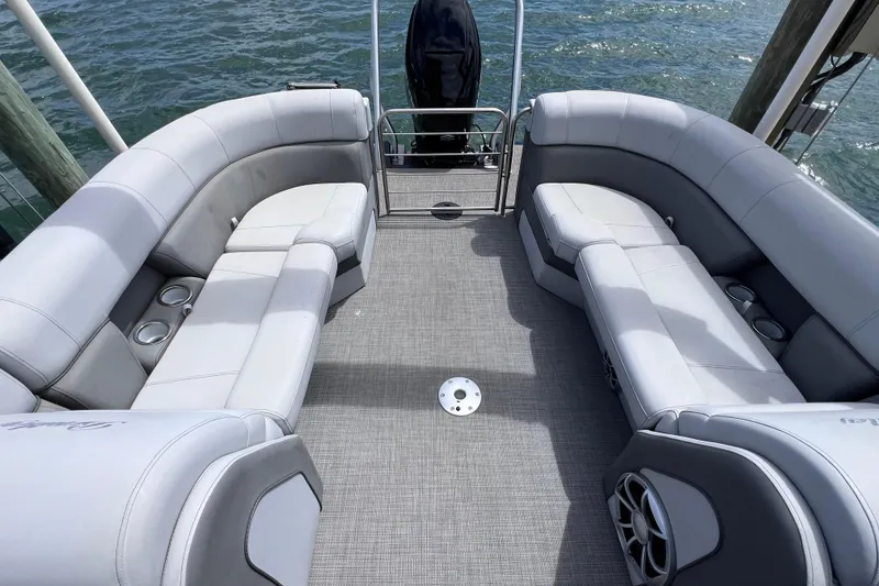 Slide: The Image of 2023 Bentley Pontoons 250 Elite Admiral interior with plush seating and cup holders on a lake. - 21