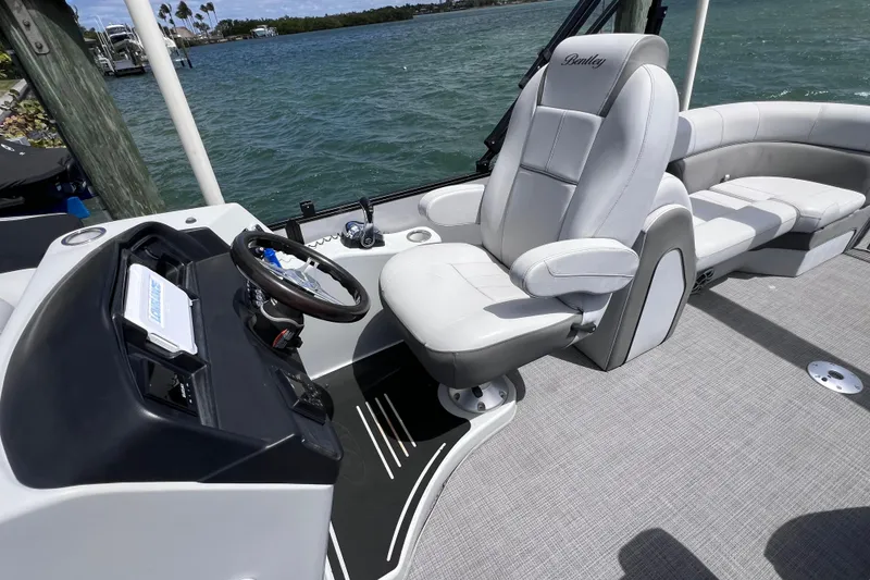 Slide: The Image of 2023 Bentley Pontoons 250 Elite Admiral interior with luxurious captain's chair and steering console. - 23