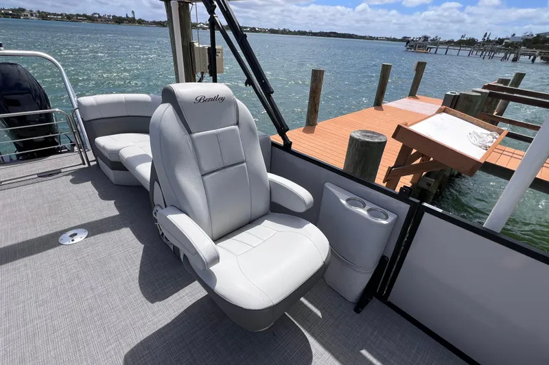 Slide: The Image of 2023 Bentley Pontoons 250 Elite Admiral boat interior with luxurious seating by the water. - 24