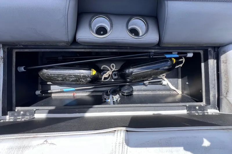 Slide: The Image of Storage compartment in 2023 Bentley Pontoons 250 Elite Admiral, featuring cup holders and equipment. - 29