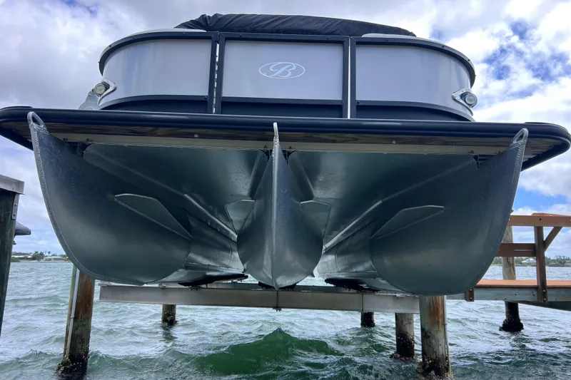 Slide: The Image of 2023 Bentley Pontoons 250 Elite Admiral on a lift, showcasing sleek design and craftsmanship. - 3