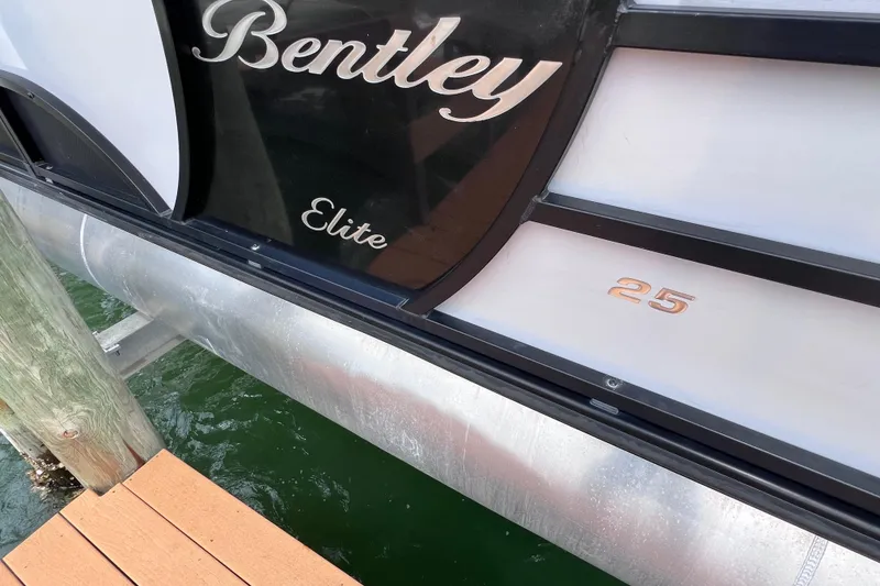 Slide: The Image of 2023 Bentley Pontoons 250 Elite Admiral docked, showcasing sleek design and branding. - 43