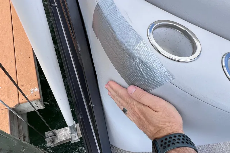 Slide: The Image of Hand applying duct tape on 2023 Bentley Pontoons 250 Elite Admiral boat seat. - 46