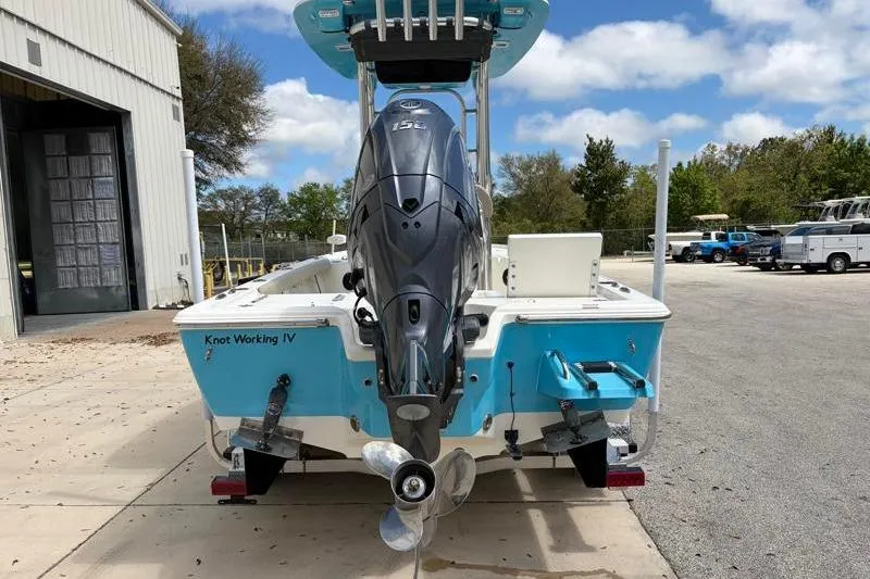 Slide: The Image of 2025 Key West 210 Bay Reef boat with outboard motor, parked outdoors. - 12