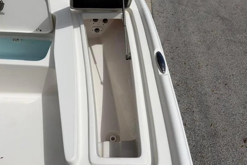 Slide: The Image of 2025 Key West 210 Bay Reef boat storage compartment, open and empty, on a sunny day. - 25