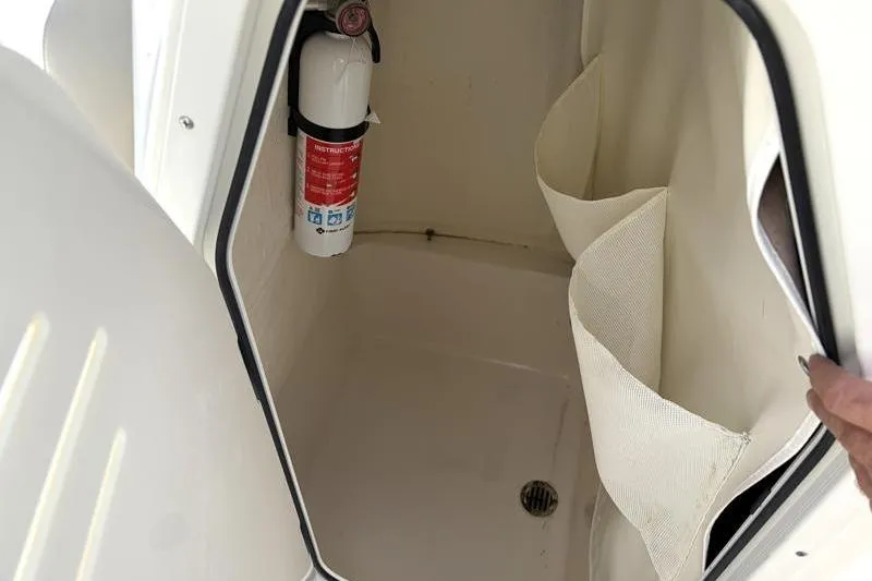 Slide: The Image of Interior of 2025 Key West 210 Bay Reef boat with fire extinguisher and storage pockets. - 32