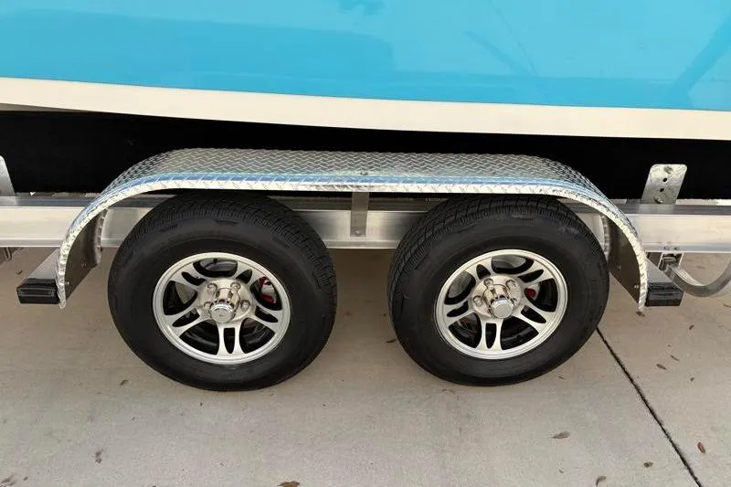 Slide: The Image of Trailer wheels of a 2025 Key West 210 Bay Reef boat on a concrete surface. - 50