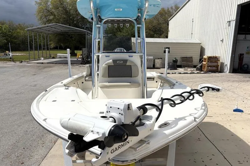 Slide: The Image of 2025 Key West 210 Bay Reef boat with Garmin equipment, parked outdoors near a warehouse. - 6
