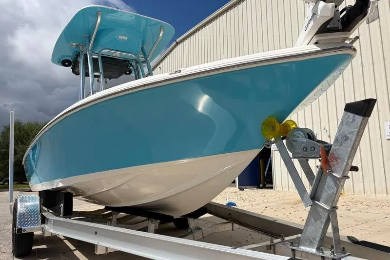 Slide: The Image of 2025 Key West 210 Bay Reef boat on trailer, blue hull, parked near building. - 8