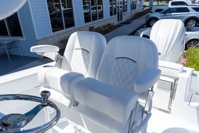 Slide: The Image of 2026 Sportsman Open 232 Center Console, luxurious white seating outdoors. - 33