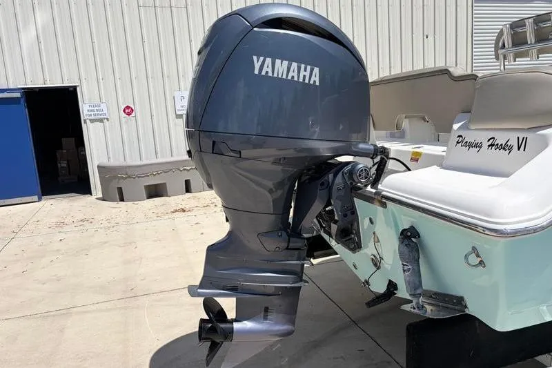 Slide: The Image of 2024 Key West 203 FS boat with Yamaha outboard motor, docked near a building. - 15