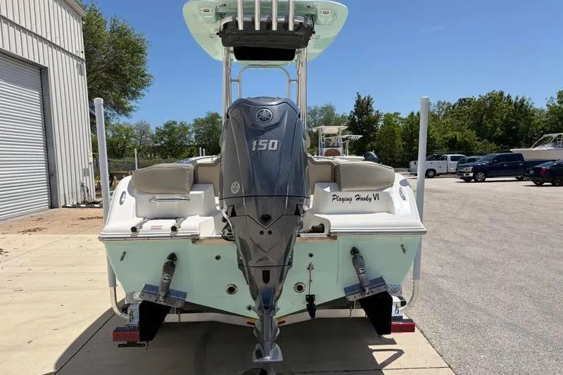 Slide: The Image of 2024 Key West 203 FS boat with Yamaha 150 engine, parked outdoors. - 12