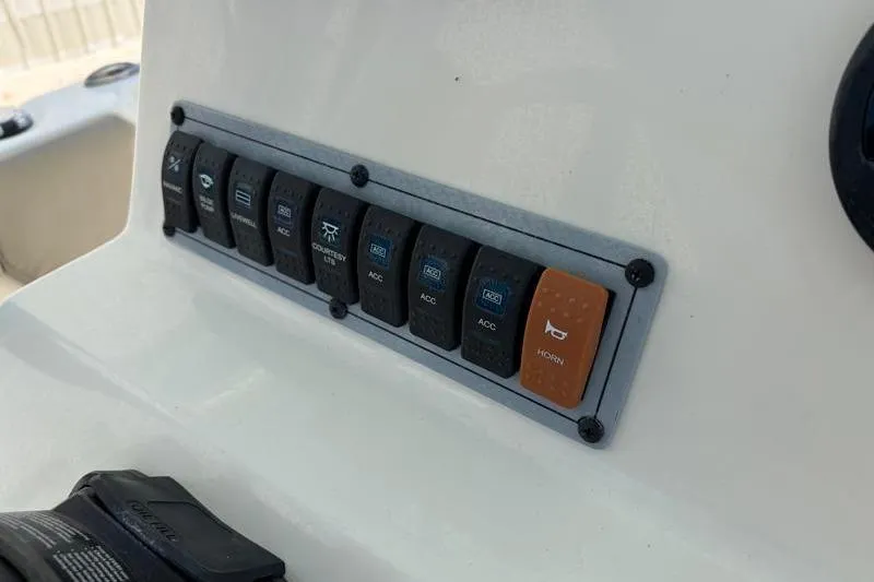 Slide: The Image of Control panel switches on 2024 Key West 203 FS boat dashboard. - 32