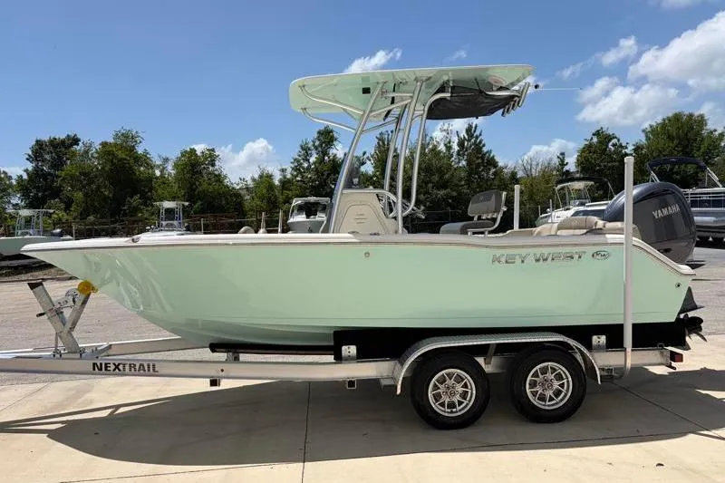 Slide: The Image of 2024 Key West 203 FS boat on trailer, parked outdoors under a clear sky. - 5
