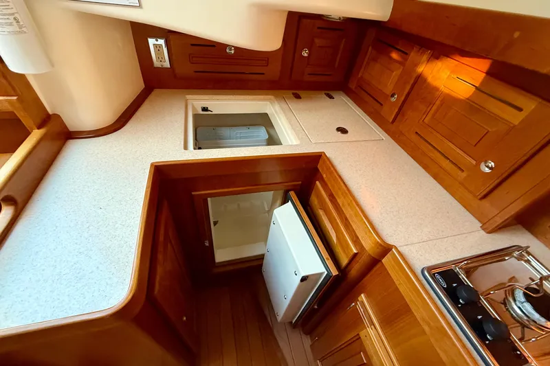 Slide: The Image of Compact kitchen area in a 2015 Tartan 4000 yacht with wooden cabinetry. - 13