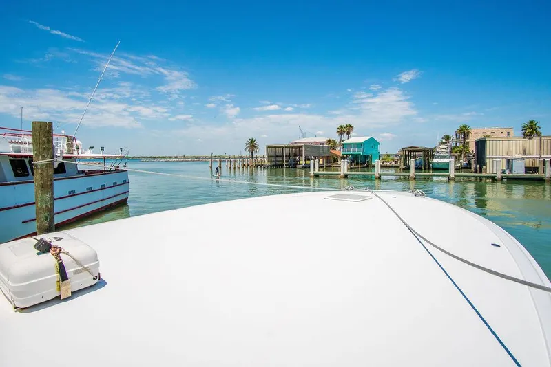 Slide: The Image of Bow view of 2014 Hatteras 63 GT yacht docked in sunny marina. - 19