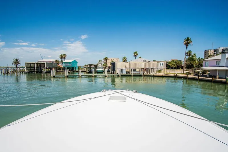 Slide: The Image of Bow view of 2014 Hatteras 63 GT yacht approaching a coastal dock. - 20