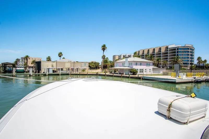 Slide: The Image of Hatteras 63 GT 2014 yacht docked in sunny marina with modern buildings. - 21