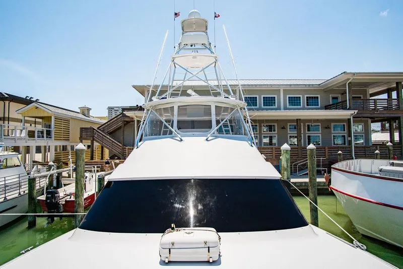 Slide: The Image of 2014 Hatteras 63 GT yacht docked at marina under clear blue sky. - 22