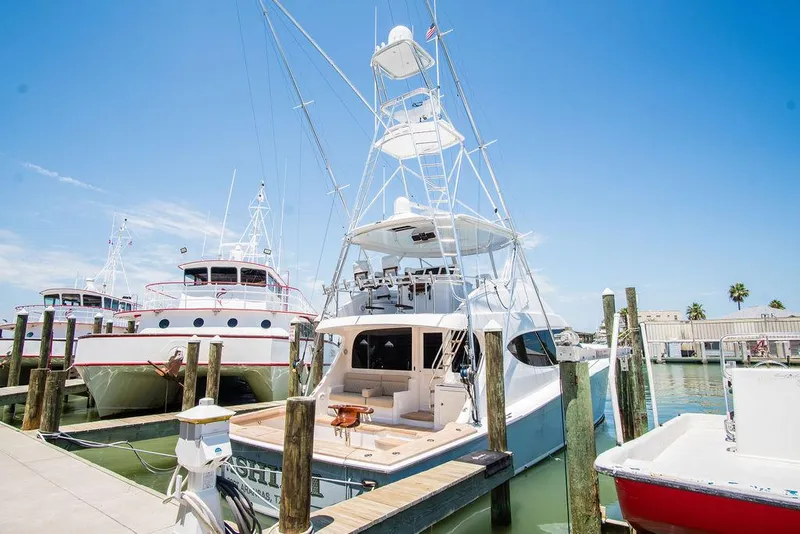 Slide: The Image of 2014 Hatteras 63 GT yacht docked at marina under clear blue sky. - 23