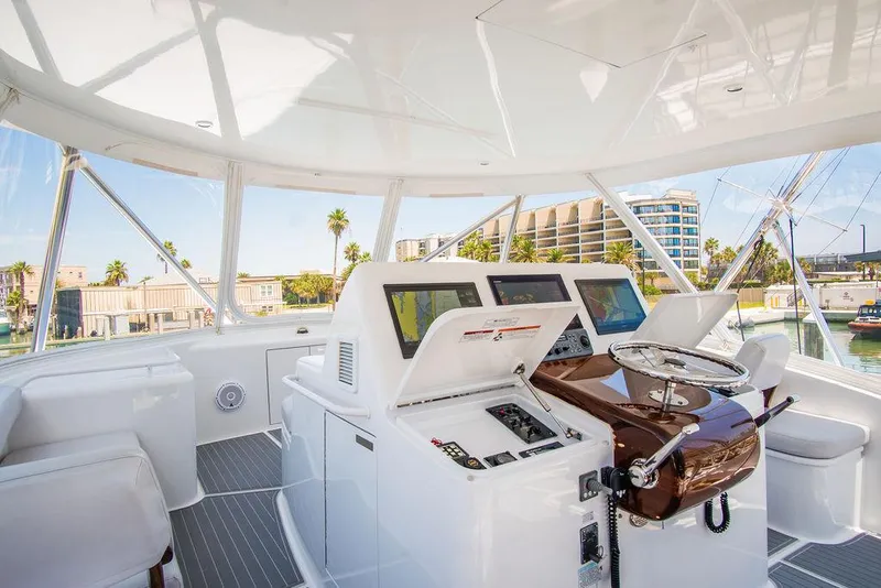 Slide: The Image of Interior view of 2014 Hatteras 63 GT yacht helm with modern controls and panoramic windows. - 27