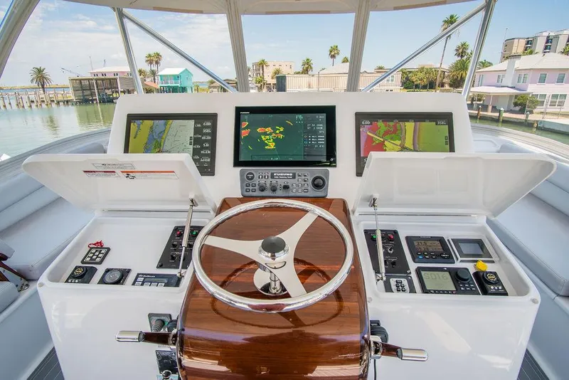 Slide: The Image of Helm of 2014 Hatteras 63 GT yacht with advanced navigation displays and controls. - 28