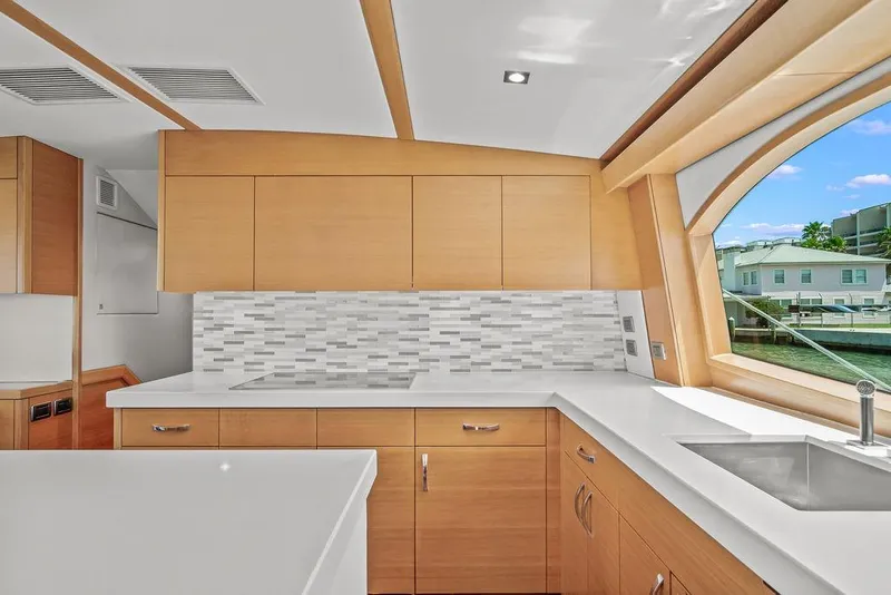 Slide: The Image of Modern kitchen interior of 2014 Hatteras 63 GT yacht with sleek cabinetry and large window. - 42