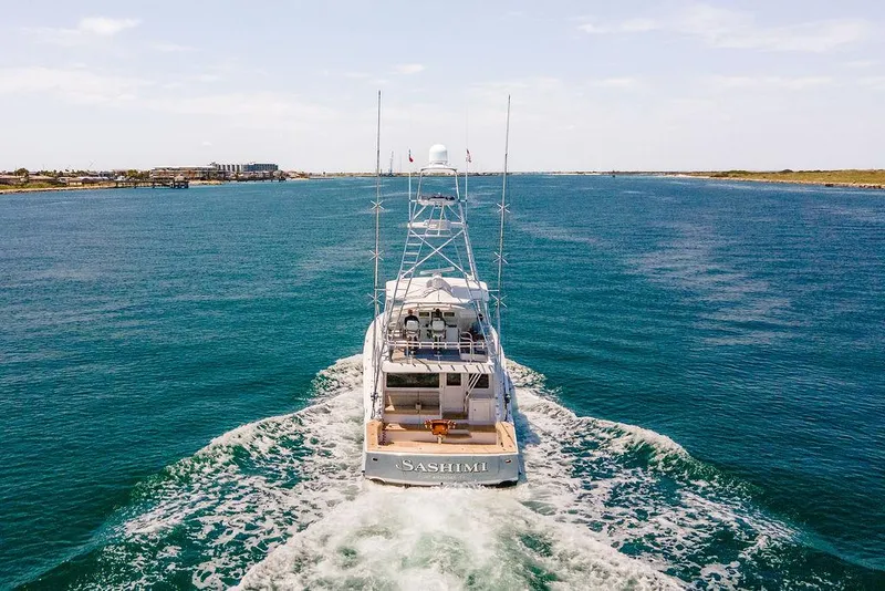 Slide: The Image of 2014 Hatteras 63 GT yacht cruising on open water, rear view. - 8