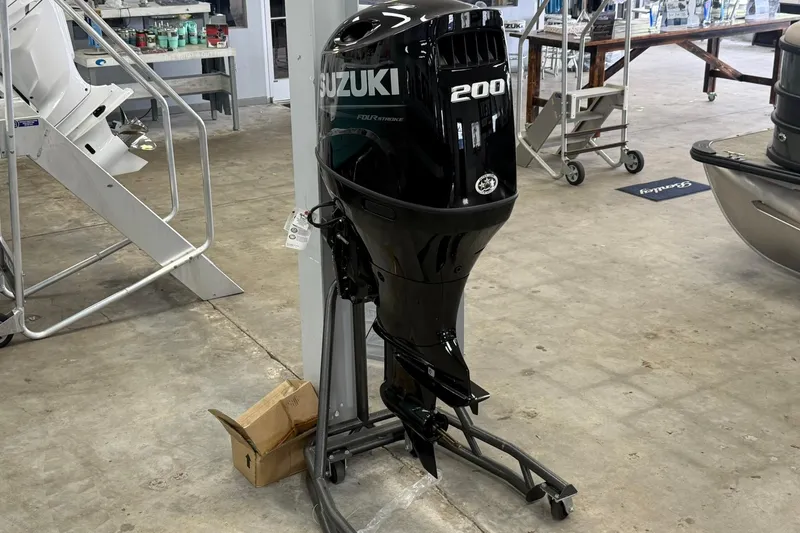 Slide: The Image of Suzuki 200 horsepower outboard motor displayed in a showroom, next to Bentley Pontoons Legacy 243 Swingback. - 7