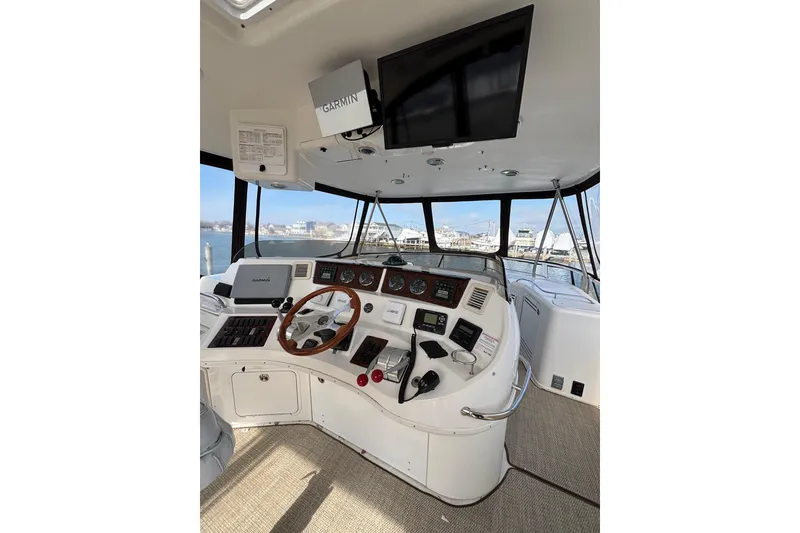 Slide: The Image of 2001 Sea Ray 560 Sedan Bridge helm with Garmin navigation, overlooking marina. - 12